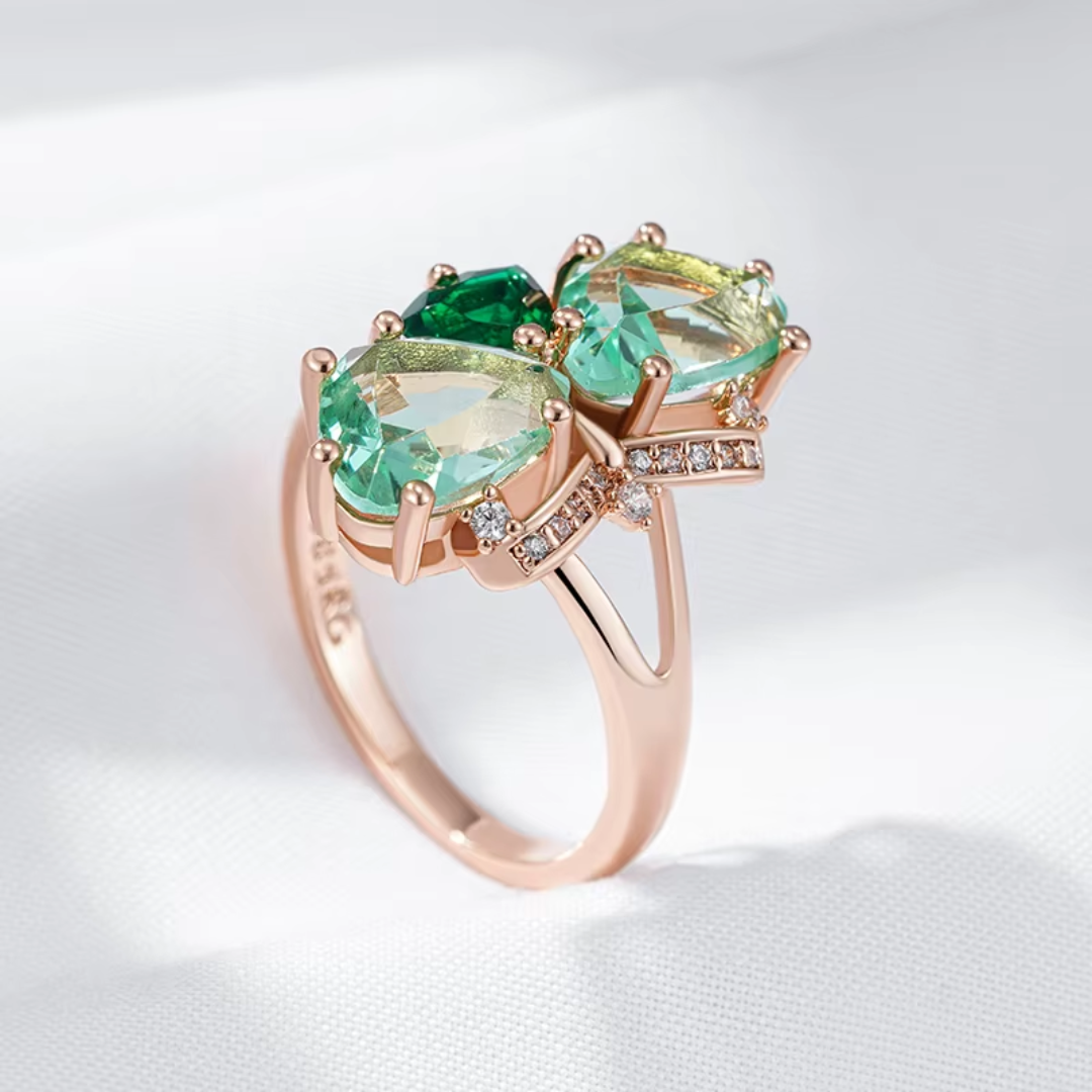 Bague en Or Rose Trio de Pierres Vertes aux Détails Élégants
