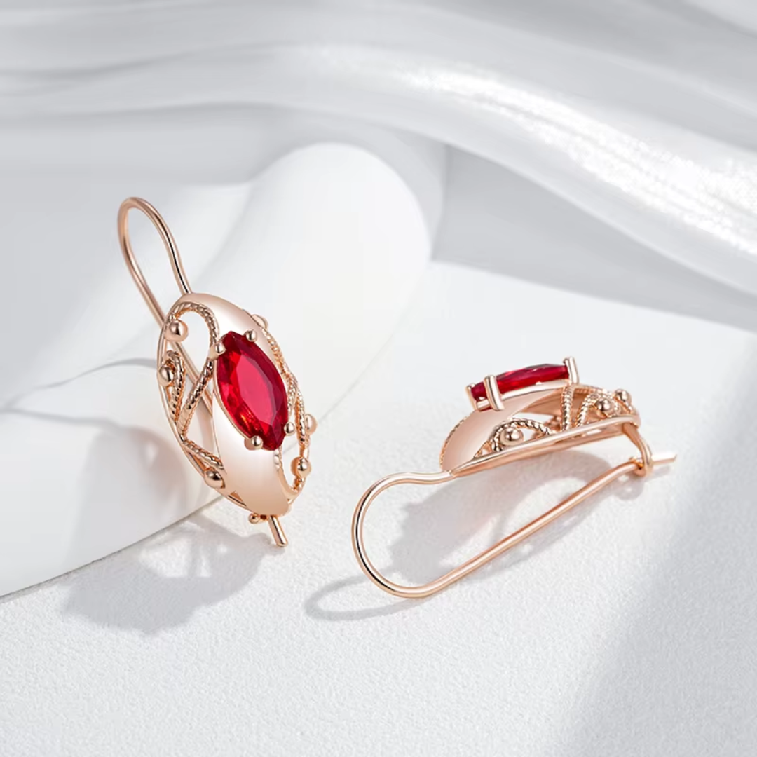 Boucles d'Oreilles en Or Rose avec Cristaux Rouges et Détails Torsadés