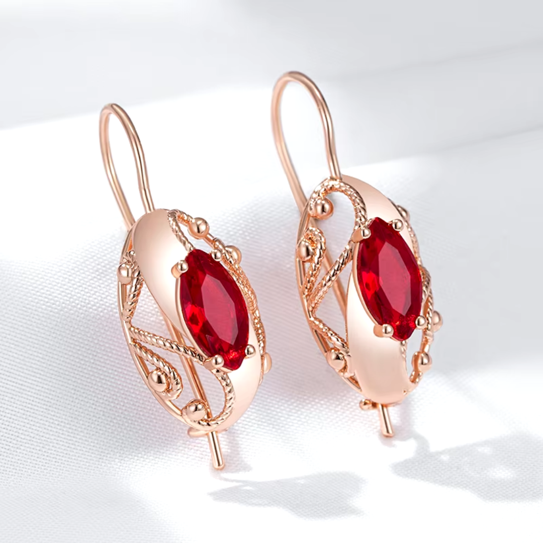 Boucles d'Oreilles en Or Rose avec Cristaux Rouges et Détails Torsadés