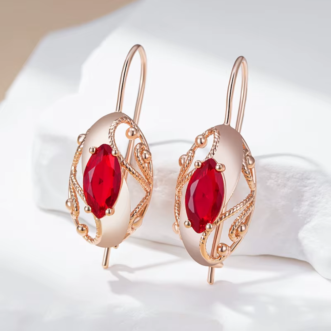 Boucles d'Oreilles en Or Rose avec Cristaux Rouges et Détails Torsadés